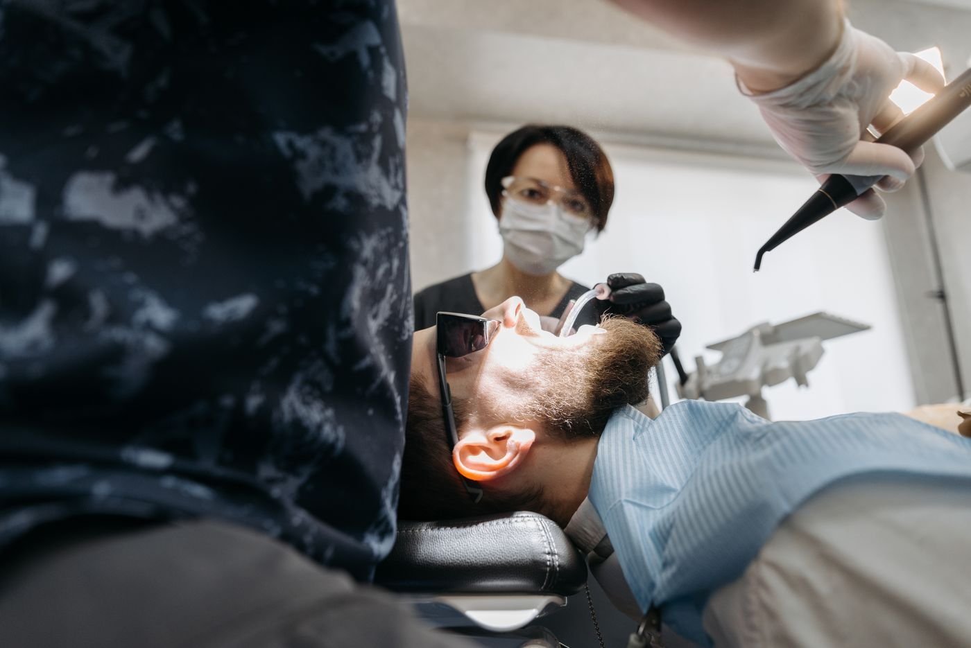 Dental team examining a patient with professional equipment