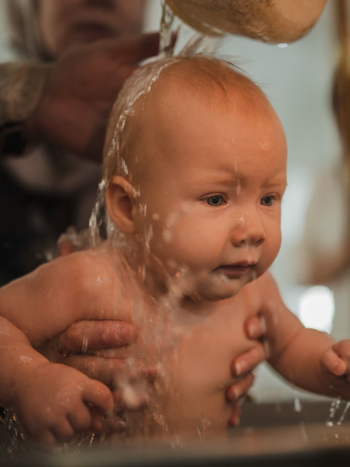 Baby being baptized with holy water