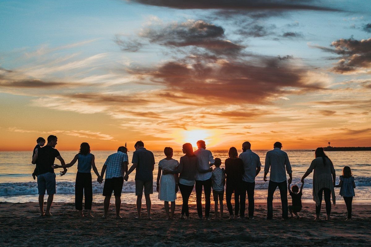 Family holding hands on the beach at sunset