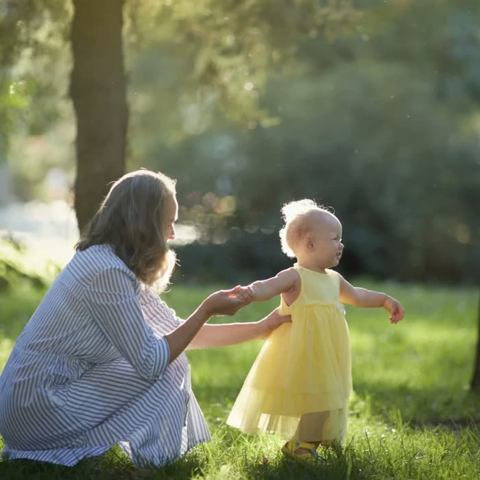Mother helping her baby take first steps