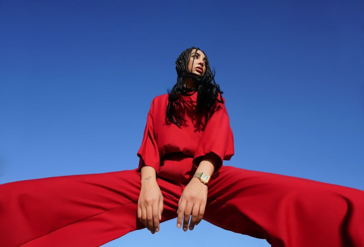 Model in a red outfit against a blue sky