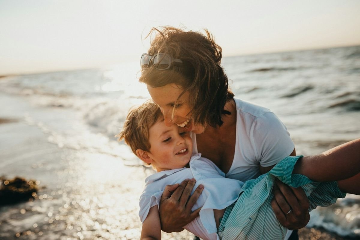 Mother holding her son by the sea