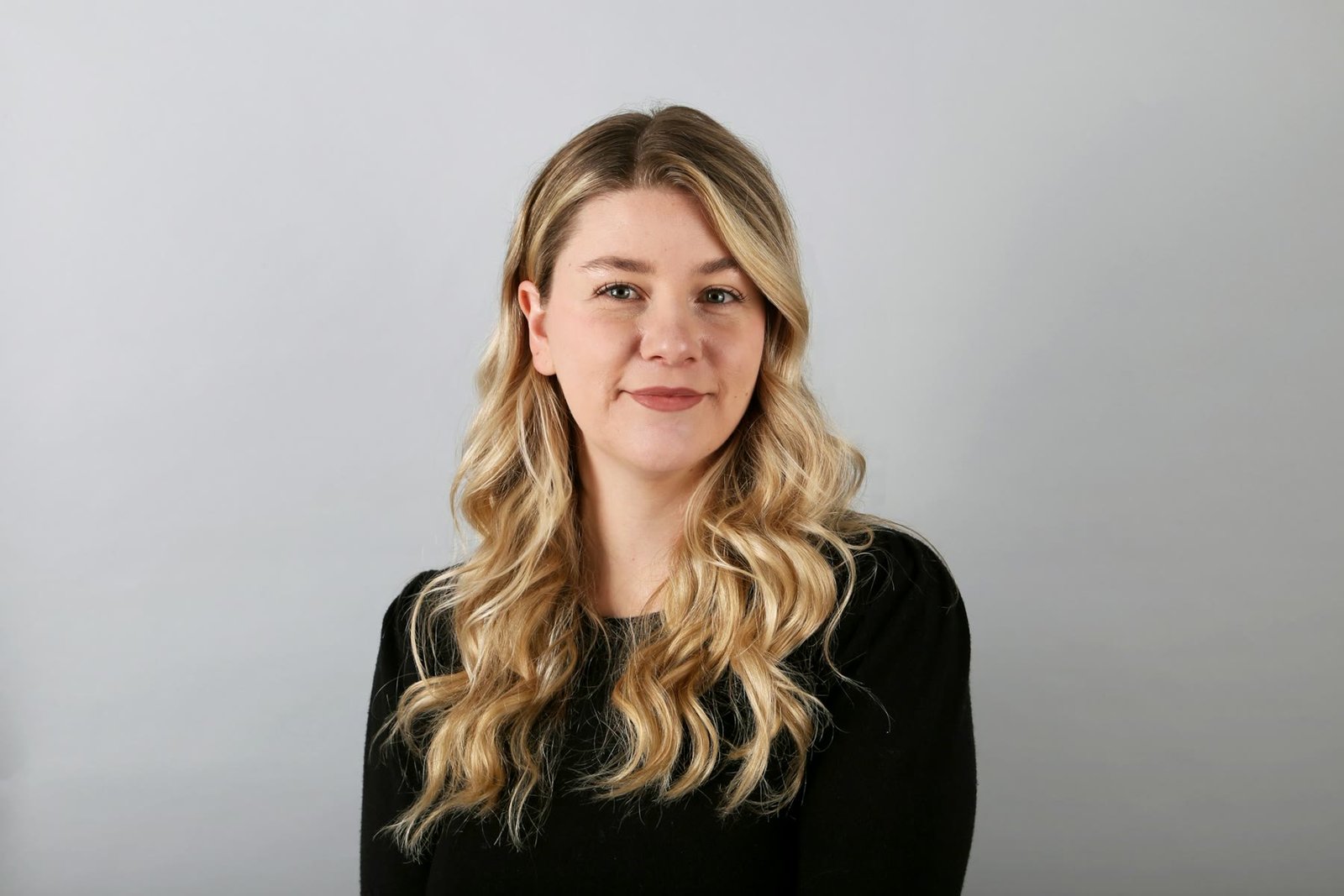 Professional headshot of a woman on a gray backdrop